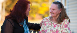 A caregiver talks to a memory care resident. 