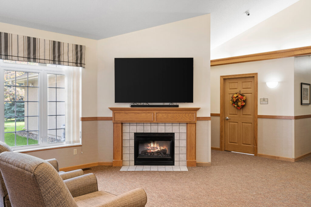 Warm gathering area with fireplace at Emerald Crest Burnsville, providing a comfortable setting for relaxation and connection.