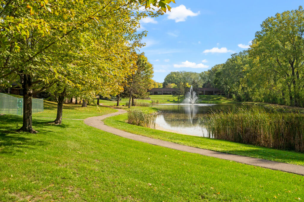 Beautiful outdoor grounds at Emerald Crest Burnsville featuring walking paths, green spaces, and scenic views.