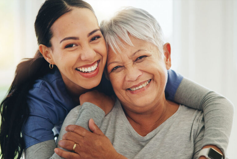 A caring moment between a resident and caregiver highlighting the personalized support, companionship, and compassionate memory care offered at Emerald Crest.